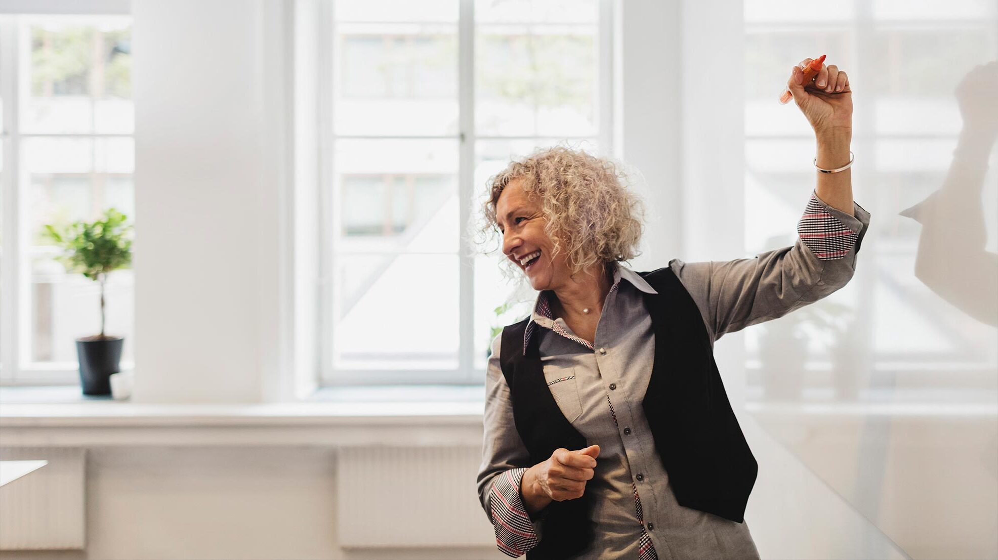 Nainen kirjoittaa valkotaululle.