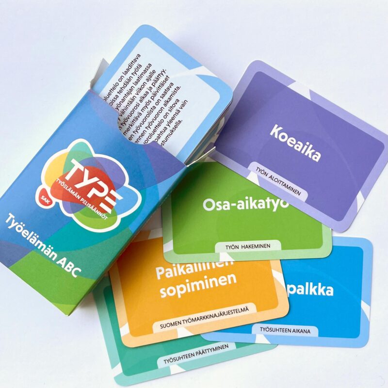 Pelikortteja pakassa ja pöydällä.